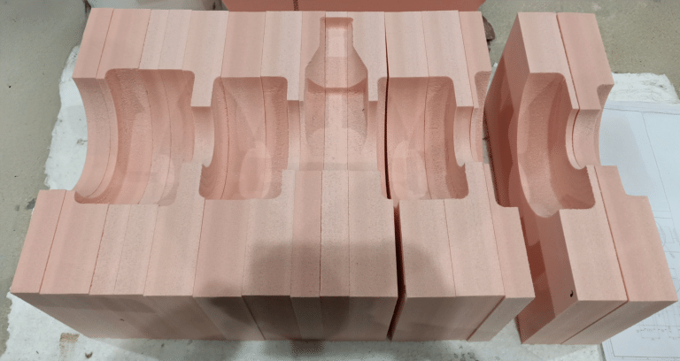 Blocs de mousse PVC rose usinés sur mesure avec empreintes semi-circulaires, réalisés par ELIT